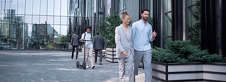 Campus Area Network – Modern switch architectures for your campus network. Glass facade of an office complex with employees walking past it