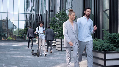 Campus Area Network – Modern switch architectures for your campus network. Glass facade of an office complex with employees walking past it