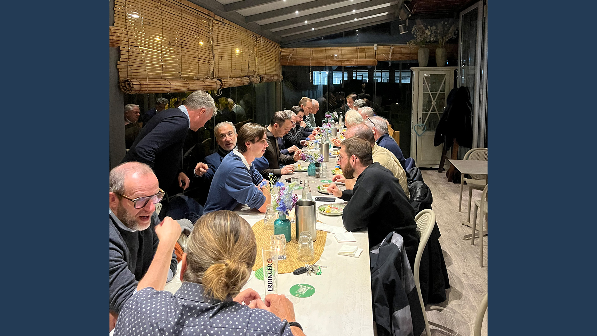 A long table at a LANCOM event where participants enjoy a shared dinner and lively discussions.