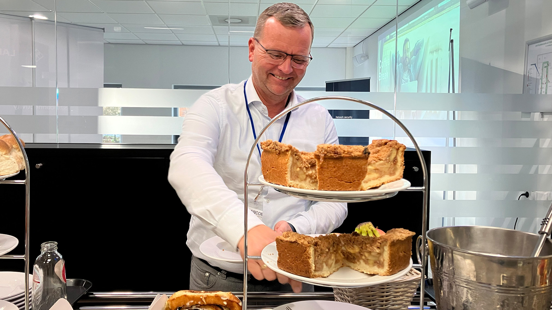 A LANCOM event participant serves himself at the buffet and takes a piece of cake.